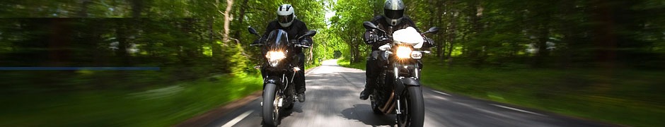Twee motorrijders op een bosweg